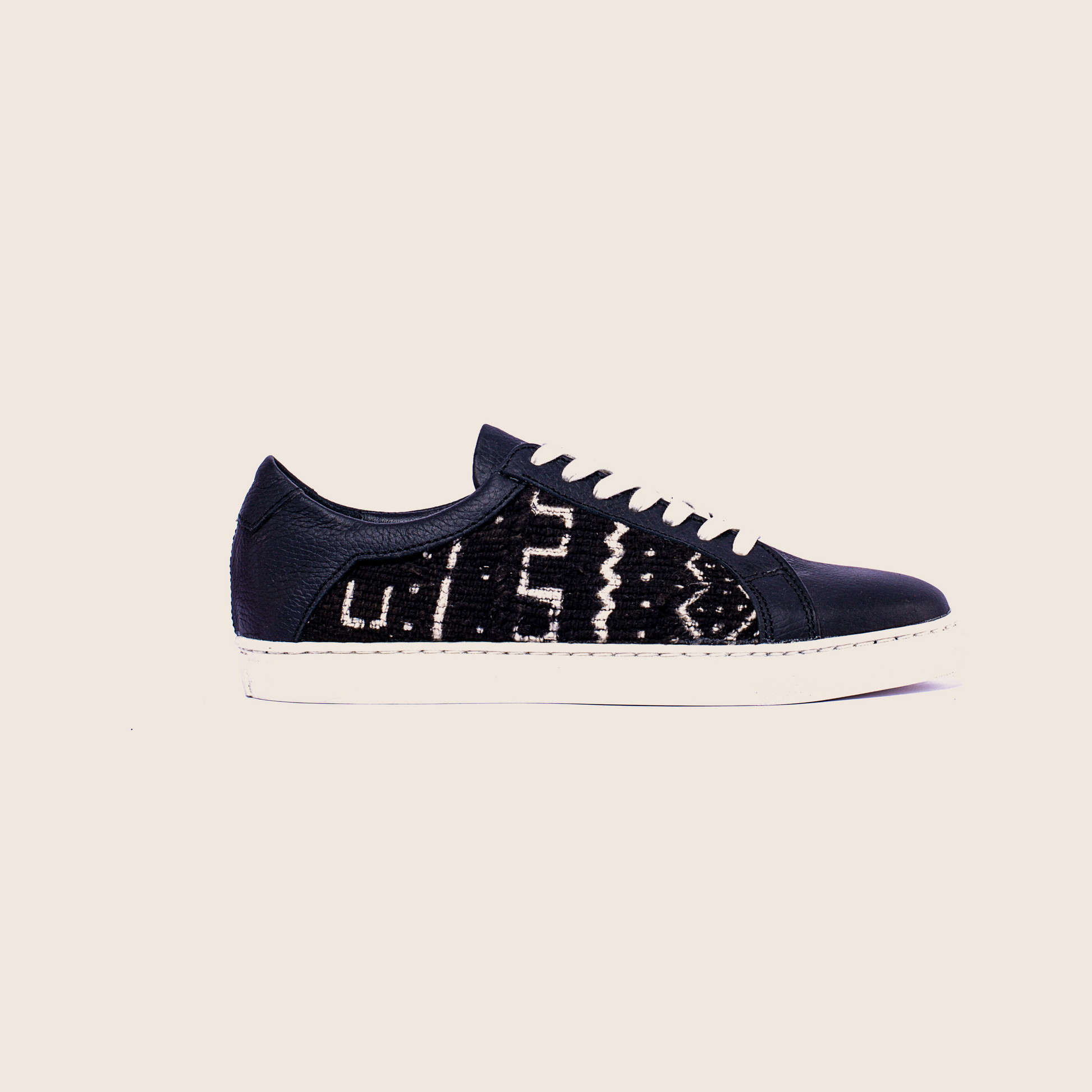 Lowtop mudcloth sneaker in black milled leather and royal soles.